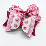 Adorable pink conversation candy heart bows, perfect for Valentine's Day!