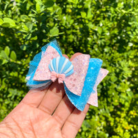 Sweet pastel pink and blue glitter bows with seashell applique!