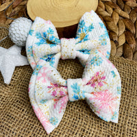 Adorable pink and blue snowflake bullet fabric bow clips or headbands.